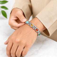 Silver chakra gemstone bracelet on wrist with blue, green, red, and orange stones