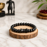 Black beaded bracelet with round beads and three dark metal-like spacer segments in center