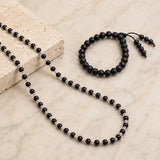 Black bead necklace with silver-toned spacers and matching bracelet, cap-style clasp