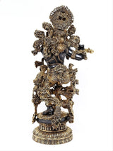 Brass Krishna idol from side view, flute raised, intricate gold filigree details