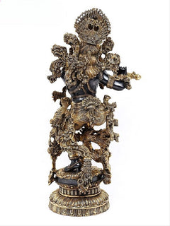 Brass Krishna idol from side view, flute raised, intricate gold filigree details