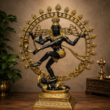 Brass Nataraja Shiva dance statue with dark figure, gold halo ring, ornate base