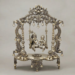 Brass Radha and Krishna jhula with ornate canopy and hanging bells, standing on base