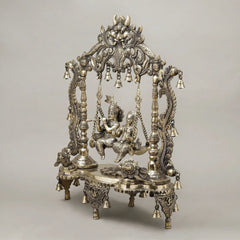 Brass Radha-Krishna jhula: detailed pillars, floral base, and hanging bell chains