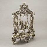 Brass Radha and Krishna swing jhula with sculpted figures and decorative frame