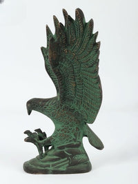 Rear view of green eagle sculpture, fan-like wings with intricate feather etching on base