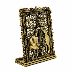 Brass Krishna and cow ornament with detailed frame, angled side view