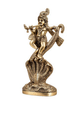 Brass Krishna Kaliya serpent statue, flute held near mouth, side view.
