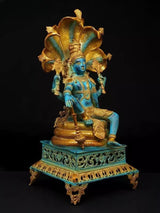 Four-armed Lord Vishnu brass idol, blue face, holding weapons, seated on carved base