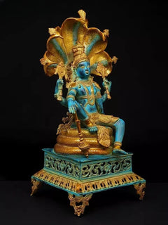Four-armed Lord Vishnu brass idol, blue face, holding weapons, seated on carved base
