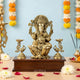 Brass Lord Ganesha idol with peacock oil lamp holders on wooden base