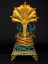 Lord Vishnu brass idol back view, flared golden canopy over seated figure, carved base
