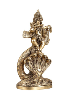 Brass Krishna dancing statue on coiled serpent base, angled view with flute.