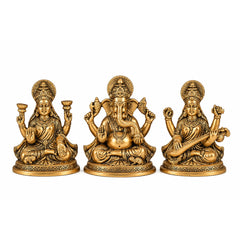 Set of three small brass deity idols seated side by side, detailed crowns and jewelry