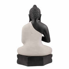 Back view of meditating Buddha statue, black body with off-white robe panel and dark base