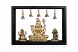 Brass seated Shiva idol with trident, framed display with hanging bells and side deities
