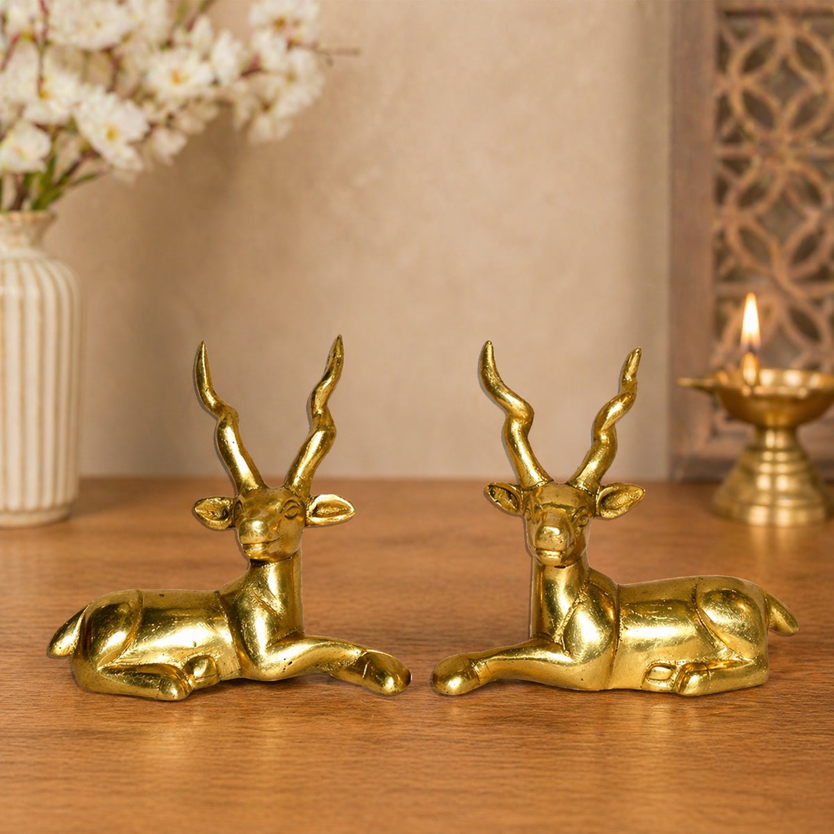 Brass sitting deer pair figurines, curled legs and raised antlers, small 4-inch set