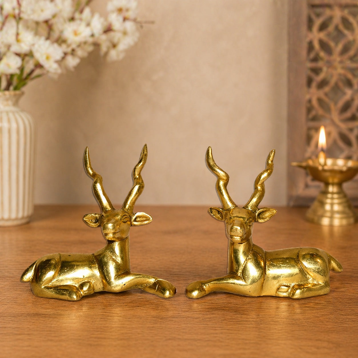 Brass sitting deer pair figurines, curled legs and raised antlers, small 4-inch set
