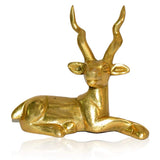 Gold-tone sitting deer figurine with upward antlers, smooth face and tucked legs