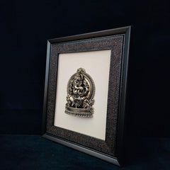 Ganesha-Relief im dunklen Rahmen, leicht schräg gestellt; mehrere Schmuckelemente am Sockel