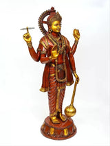 Brass four-armed Vishnu idol holding conch and discus, red robe with gold trim.