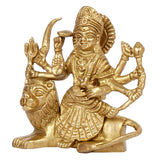 Brass Durga idol from side view, seated on lion with raised weapons and ornaments