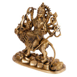 Brass Durga idol on lion, angled view with spiked crown and trident-like weapon hand