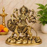 Brass Durga goddess idol seated on lion, four arms holding weapons, home mandir decor