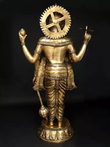 Brass back view of four-armed standing Lord Vishnu with circular halo and weapon hands