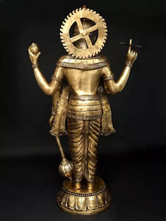 Brass back view of four-armed standing Lord Vishnu with circular halo and weapon hands