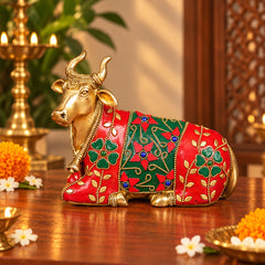 Brass Nandi bull idol with jeweled stonework, red and green painted body, kneeling