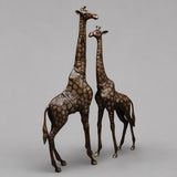 Antique copper brass giraffe figurines, side view of two standing with raised heads