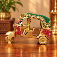 Decorative brass auto rickshaw with green roof, red bead panels, gold detailing, side view