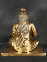 Brass Valmiki sculpture from behind, long hair draped over shoulders, seated cross-legged