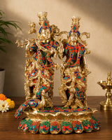 Brass Radha-Krishna statue with colorful meenakari, two figures, ornate base.