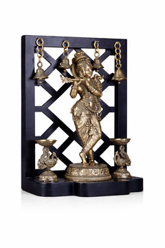 Brass Lord Krishna idol with hanging bells, dual lamp holders on stand