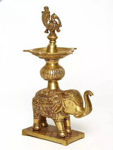 Brass oil lamp with peacock topper on elephant stand, engraved details