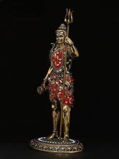 Shiva brass idol holding trident, one hand raised, red-and-green ornate outfit, 12 in