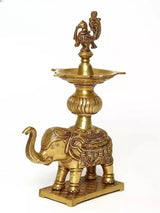 Brass peacock oil lamp on elephant pedestal, curved trunk detail