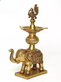 Brass peacock oil lamp on elephant pedestal, curved trunk detail
