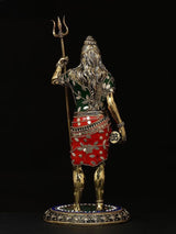 Shiva brass idol from behind, trident held high, red-and-green skirt and beads, 12 in