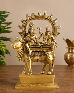 Brass Shiv-Parvati statue seated on Nandi with ornate halo arch, mounted on base