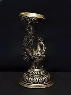 Brass peacock diya standing figure with flared bowl and engraved swirl details