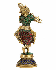 Brass Krishna statue back view with ornate green, red and blue jeweled details