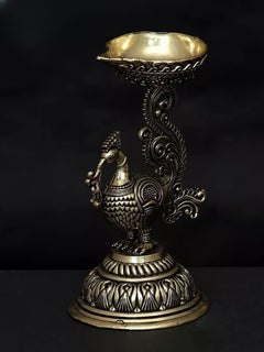 Brass peacock diya statue, angled view showing ornate bowl and tail filigree