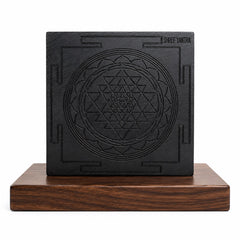 Karungali wooden Shree Yantra plaque with centered engraved yantra in dark square, on wooden stand