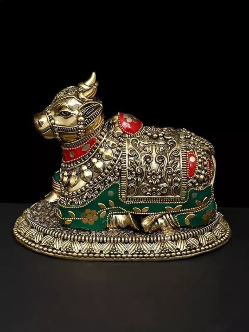 Brass Nandi statue with red and green enamel, ornate saddle, side view