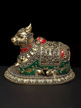 Brass Nandi statue with red and green enamel, ornate saddle, side view