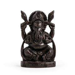 Black seated Lord Ganesha statue with detailed trunk, crown, four hands, and carved pedestal