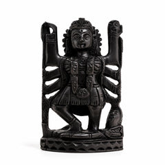 Dark carved Kali deity idol figurine with raised arms and crown, seated on base